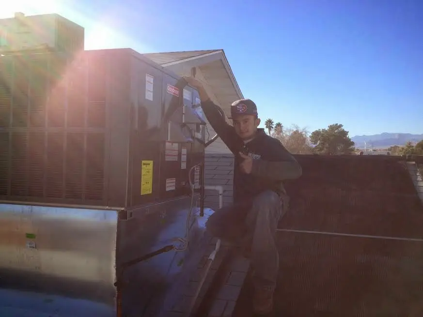 HVAC technician performing Heat Pump Repair on a rooftop unit in Bardstown